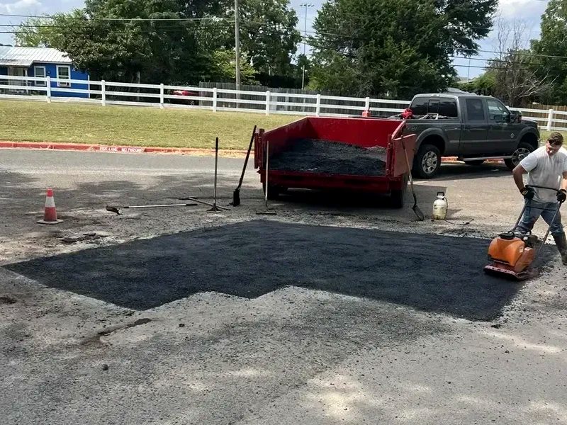 Crew patching asphalt on a commercial lot
